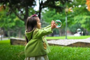 a child reaching out to a large bubble