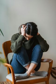 a person sitting with their head in their hands