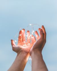 hands held out, palms up with fairy lights